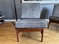 Front view of chair showing seat and back cushions on teak frame