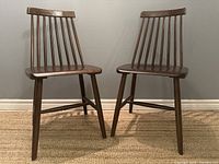 Front view of pair of chairs side by side against gray wall
