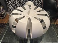 Top-angle view of the vintage IKEA Stockholm pendant lamp showing multiple curved white panels arranged in a circle.