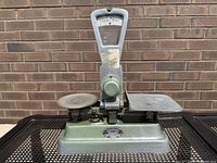 Photo of the full vintage Exact Weight Scale showing the green metal body with dual platforms and central dial indicator.