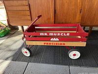 Front and side view of the vintage Mr Muscle Precision wagon showing the red wooden slats and lettering.