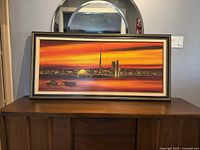 Front view of the framed vintage original oil painting of the Toronto skyline prominently showing warm sunset colors and cityscape details.