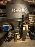 Front view of Tohatsu MD40 motor on pallet showing cowling and hoses