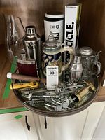 Overall lot overview showing all items including shakers, flask, boxed Corkcicle, stein pitcher, mixing spoon, multiple bottle and cork openers on a metal tray.