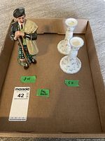 Overview of all three items on a cardboard tray showing the golfer figurine and two candle holders with size labels.