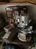 Photo showing Craftsman 924600 router with original box and hard plastic case on a wooden surface.