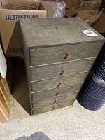 Front angle view of the cabinet showing five drawers and pink knobs