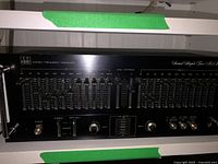 Overall angled front view of ADC stereo frequency equalizer showing entire control panel including left and right channel equalizers, power switch, and audio source selectors.