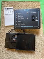 Heart Interface Energy Management System panel with control switch and status LEDs, lying on carpet next to lot label.