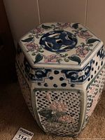 Front-left angle view showing the hexagonal shape, perforated panels, and floral decorations