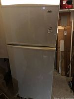 Full view of Inglis white top freezer refrigerator showing both freezer compartment on top and fridge below.