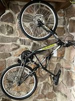 Full view of black and yellow Kent mountain bike showing frame, wheels, saddle, and suspension.