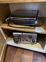 Side view of sandwich press and toaster inside cabinet shelf