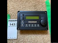 Magnum Energy control panel showing front face with LCD screen, status LEDs, buttons, and selector knob.