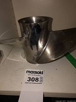 Close-up photo of one blade of the metal propeller showing its curved shape and metal surface with some wear marks.