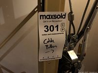 Close-up photo showing MaxSold lot tag attached to wire rope cable with two metal hooks.