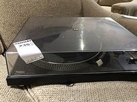 Front view of turntable with dust cover closed showing overall condition and brand label.