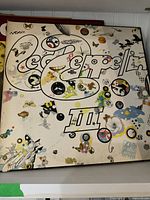 Led Zeppelin III album cover with white background and circular illustrations.
