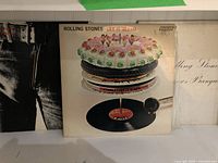 Front cover of Rolling Stones Let It Bleed album showing cake and record illustration