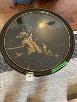 Top view showing the glass tabletop and the Asian-inspired gold scenic design beneath it, including birds, plants, and landscape details.