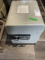 Full view of light gray Sentry safe 1250 model showing top and front including taped combination instructions and dimension label.