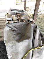 Front view of white fiberglass tender partially covered on dock