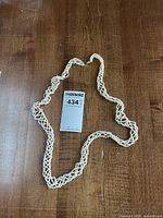 Full view of the multi-strand seed pearl necklace laid flat on wooden surface.