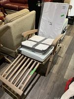 Assembled chair frame with white wrapped cushions strapped on seat