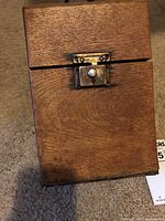 Closed oak wooden box with brass latch on front