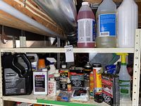 Shelving with mix of automotive and household maintenance products including motor vehicle antifreeze, acetone, teak oil, epoxy glue, and air tool oil cans.