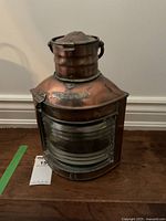 Full view of the vintage copper ship's lantern showing domed top, glass panel front, and handle.