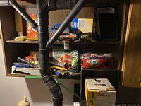 Wide view of shelf with assorted painting supplies including steel wool, brushes, and trowels