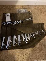 Fabric roll-up case with full-size wrenches and plastic bag of stubby wrenches