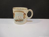 Side view of the ceramic mug showing the image of a ship, Canadian flags, and a man's portrait on a cream background with gold trim.