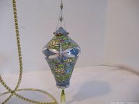 Full view of Bradford Edition Heirloom ornament with floral and dragonfly design showing its shape and colors.