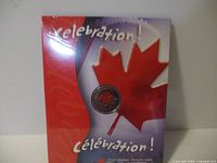 Front view of the coin's packaging showing a large red maple leaf and 'Celebration' text in English and French, coin visible in center.