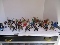 Wide view of all toy figures including knights, Robin Hood, and other characters on a white surface.