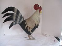 Front and side views of a large metal rooster garden sculpture with painted details and metal legs.
