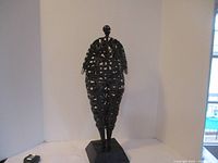Front view of welded woven metal lady figure on hexagonal base against white background showing full height and shape.