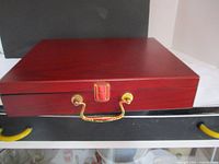 Closed polished wooden case with gold clasp and handle