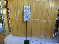 Full view of the lamp against closet doors showing height and overall design