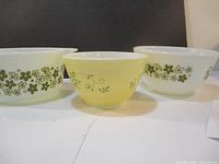 Front view showing three vintage Pyrex mixing bowls in different sizes and designs