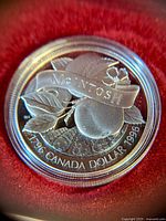 Close-up of the front face of the silver dollar coin showing the apple and banner design with 'McIntosh' and the dates 1796 and 1996.