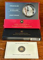 Front view of coin in original packaging showing detailed Totem Pole design and packaging text.