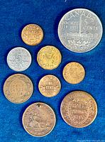 Top view of the collection of coins including Canadian cents, nickels, and world coins arranged on a blue cloth.