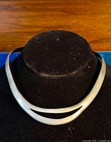 Front view of the sterling silver modernist choker necklace displayed on a black velvet stand.