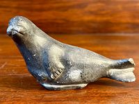 Soapstone seal carving side view showing details and texture.