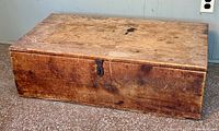 Top and front view of antique wooden chest showing the worn surface and locking mechanism.