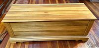 Front view of the cedar chest showing the wood grain and lid design.
