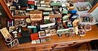 Overall display of multiple boxes containing jewellery pieces on wooden dresser under mirror